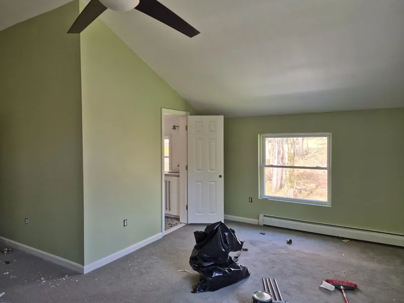 Bedroom with fresh sage-green walls and new trim